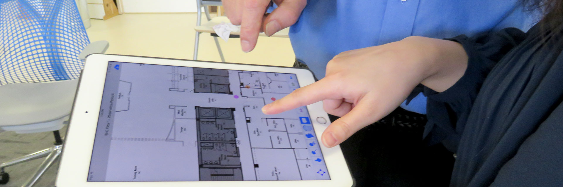 Researchers look at a floorplan on a laptop.
